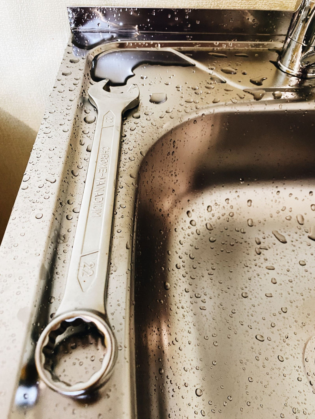 Wrench beside a kitchen sink for plumbing repair